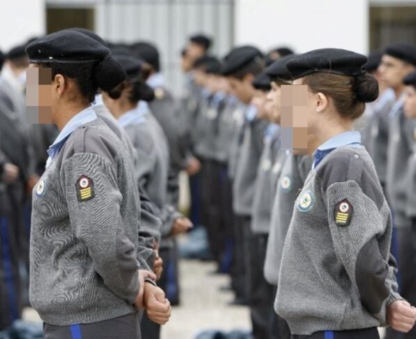 imagem colorida mostra pessoas vestidas com uniforme de escola militar, enfileiradas e com as mãos para trás - metrópoles
